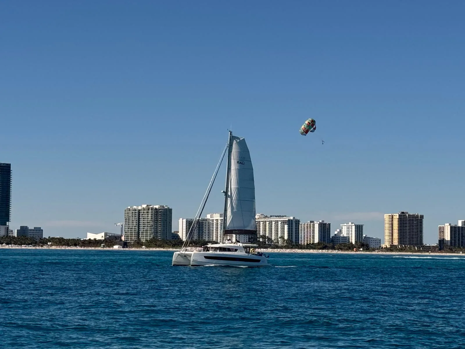 A catamaran sailing along the city coastline
